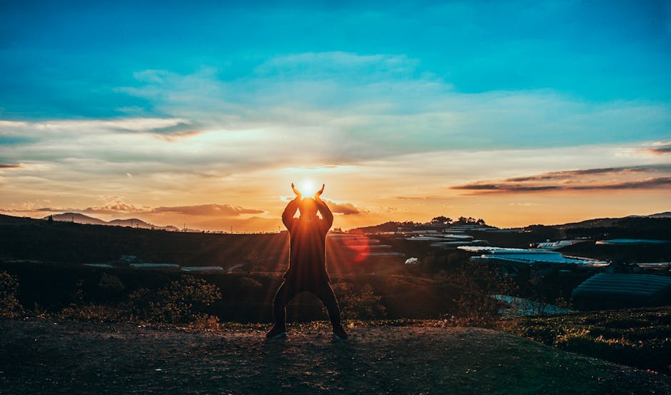 Silhouette of person at sunrise with arms raised - spiritual awakening and new beginning