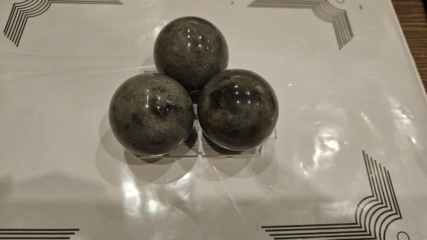 Three labradorite spheres 40mm close-up showing polish and labradorescence