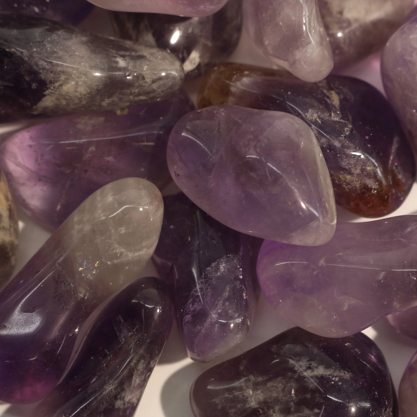 Genuine amethyst tumbled stone on white background displaying spiritual crystal clarity