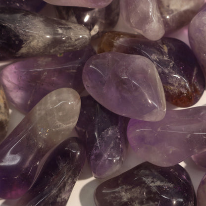 Genuine amethyst tumbled stone on white background displaying spiritual crystal clarity